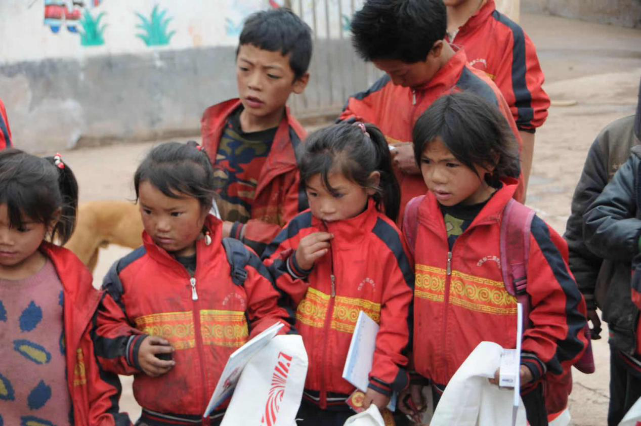 5依楚村的孩子们拿着慰问团送来的学习用.png